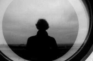 A silhouette of a man framed in a round window